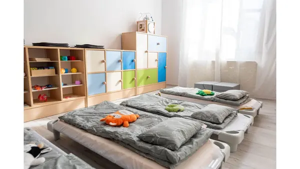 Sypialnia żłobkowa z regałami na zabawki